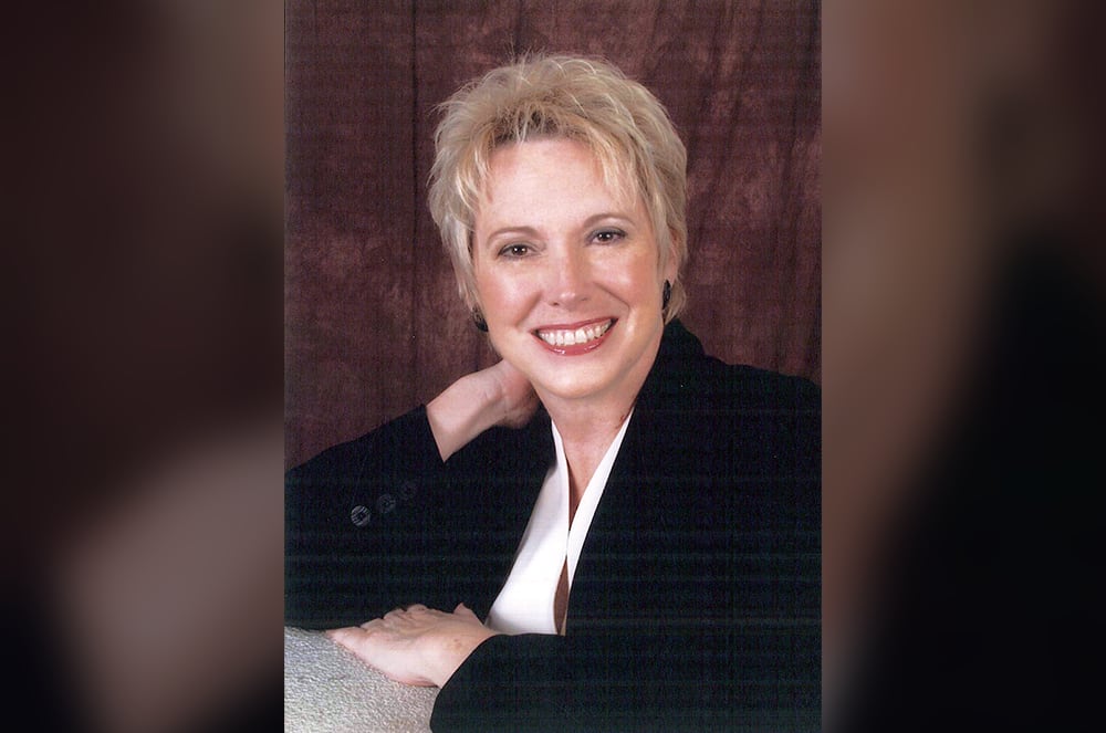 Woman in black suit jacket smiling