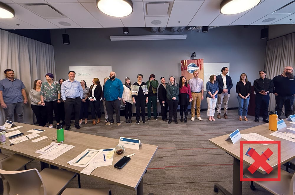 A group of people lined up in a row with desks in front of them