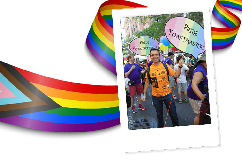 Man in orange shirt holding a sign shaped like a speech bubble