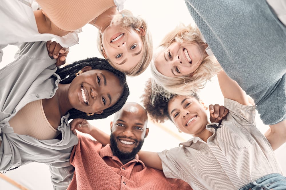 Five people smiling in a circle