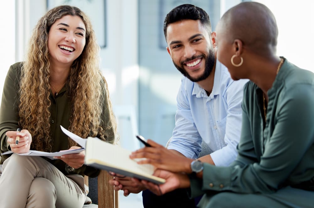 Three people working together with notebooks