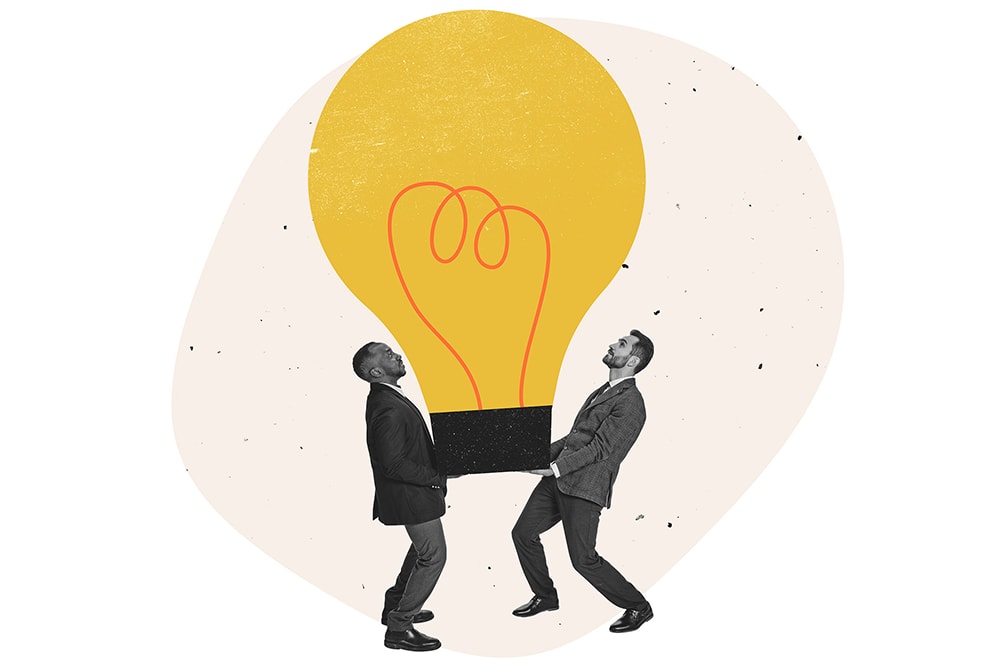 Two men carrying a cartoon lightbulb