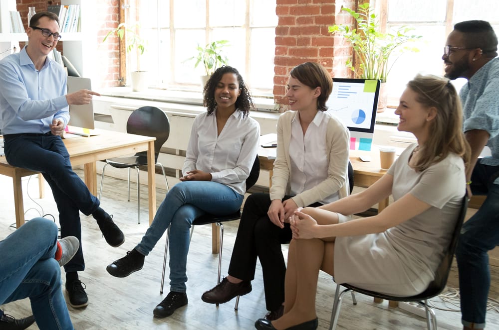 Group of people in business attire talking in an office