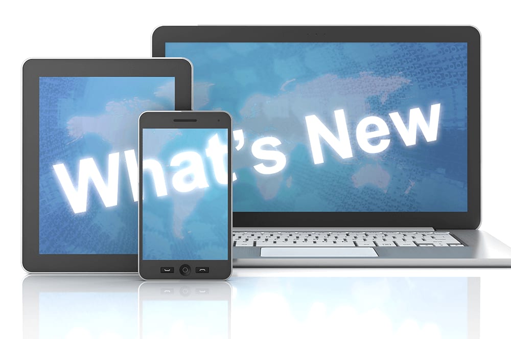 The image displays various digital devices, including a tablet, a smartphone, and a laptop, all displaying the text "What's New" against a cloudy blue sky background.