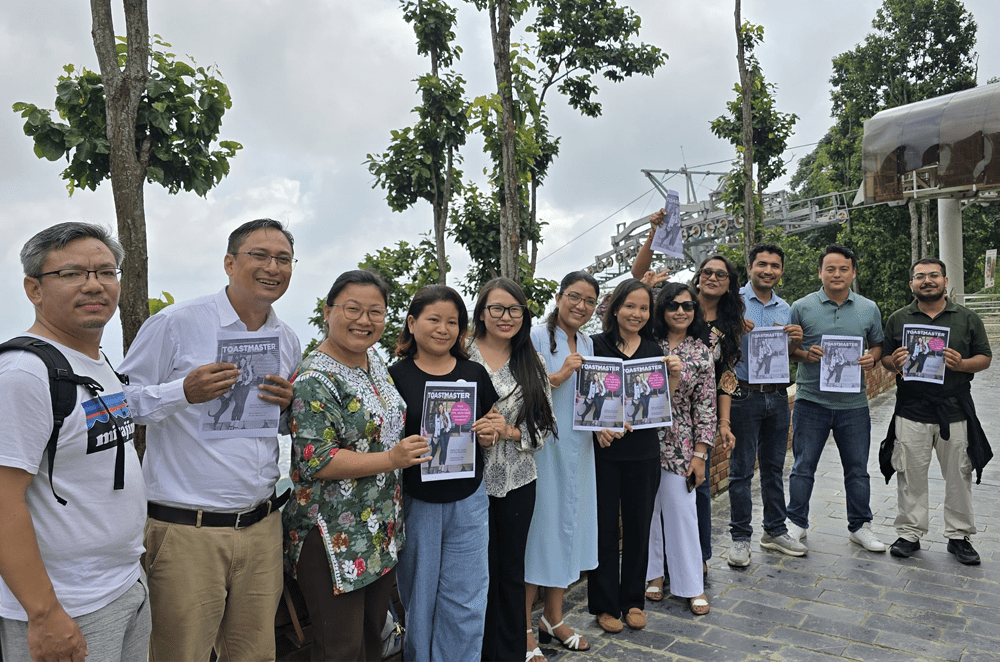 A group of people standing outside and holding printed covers of a magazine