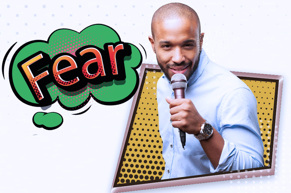The image shows a smiling man holding a microphone in front of a large "Fear" graphic.