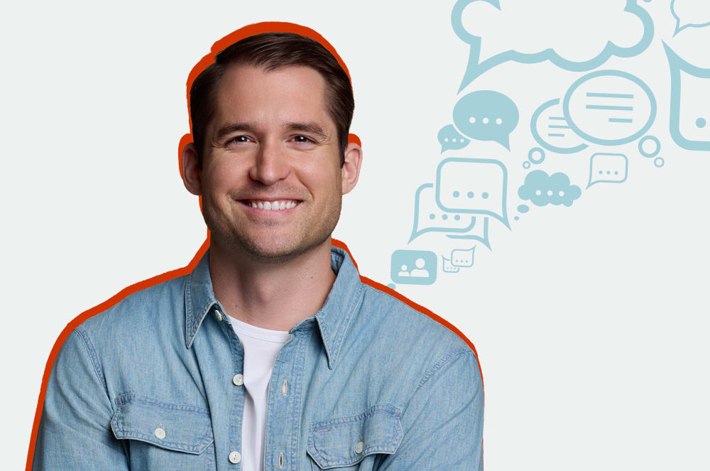 A smiling man wearing a denim jacket and an orange beanie stands in front of a background with speech bubble icons.