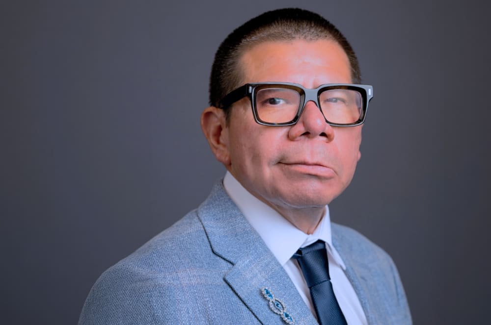A man wearing glasses and a suit and tie