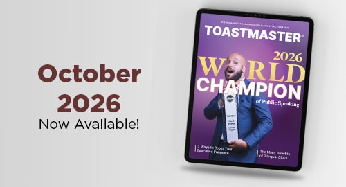 A digital tablet displaying a Toastmaster magazine cover featuring a world champion of public speaking sits against a light grey background with the text "October 2026 Now Available!".