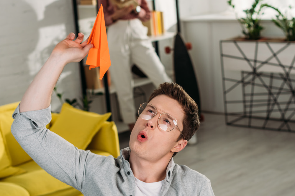 A man sitting in an office throwing a paper airplane