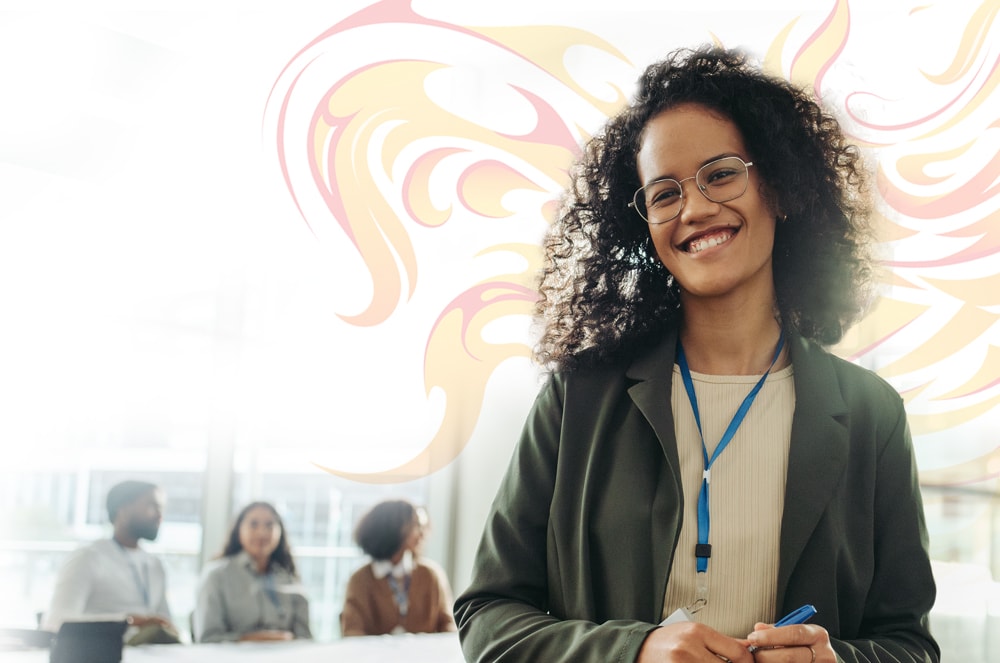 A smiling woman holding a pen inside of an office