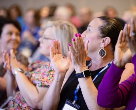 A group of people with their hands raised, appearing to be engaged in a collective activity or event.