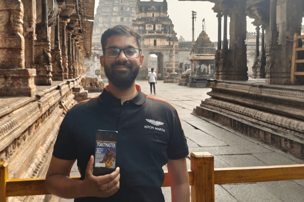 Aditya Saxena, DTM, of Noida, Uttar Pradesh, India, shares the digital Toastmaster magazine while visiting the Virupaksha Temple in Hampi, Karnataka, India.