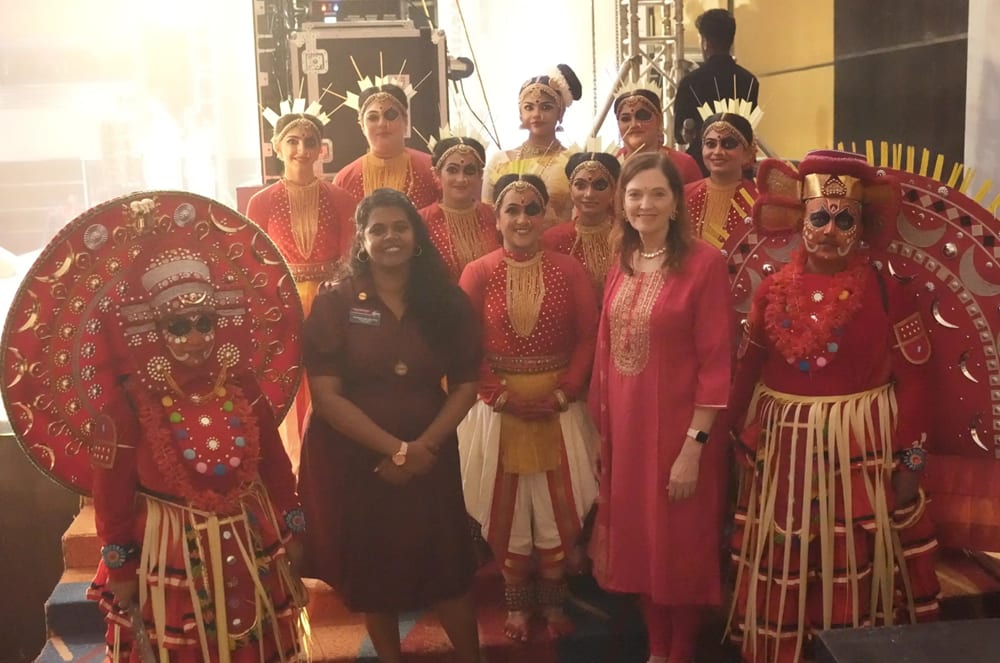 Rochat at the District 121 Crescendo Conference in India, with then-Region 13 Advisor Vanitha Rangarajan and traditional dancers who performed. Photo credit: Varadham Media