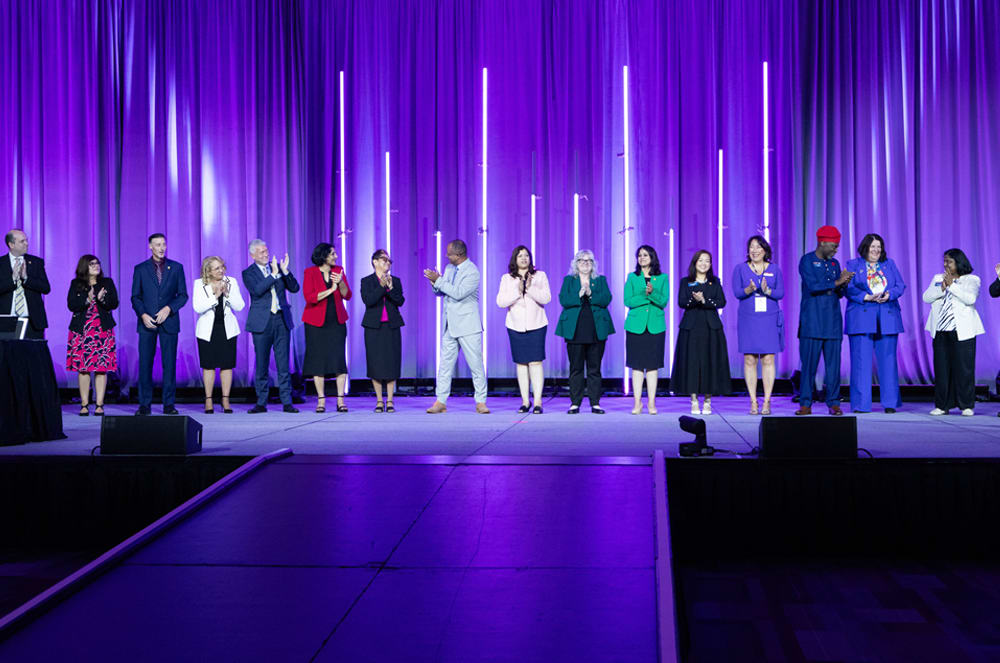 2026-2027 Executive Committee and International Directors applaud one another. 